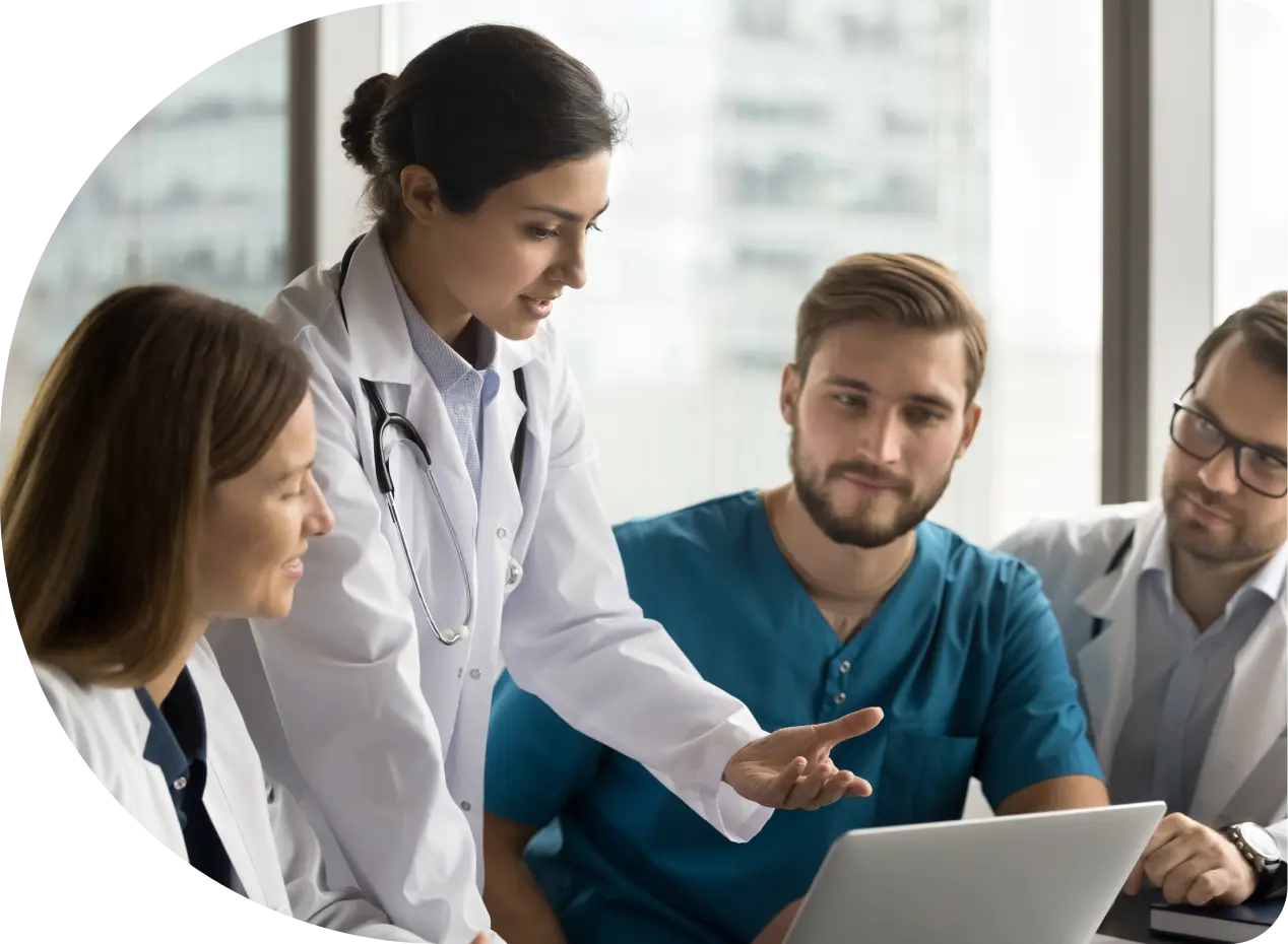 four employees looking at laptop
