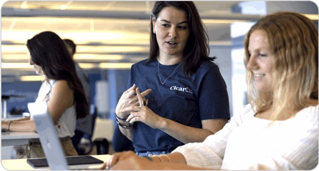 two employees discussing talent management on computers