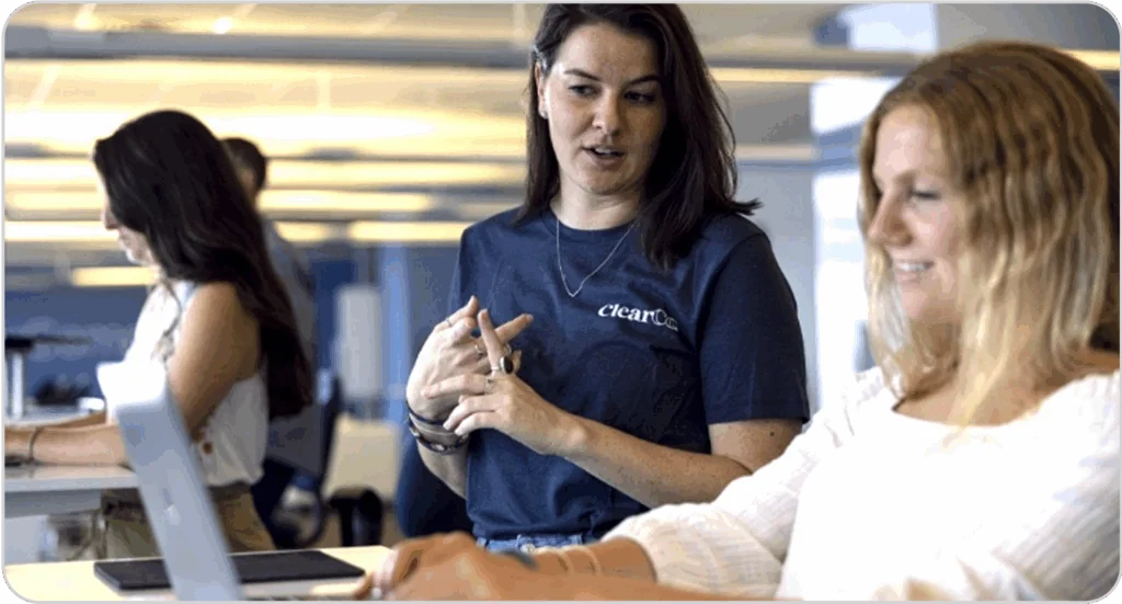 two employees discussing talent management on computers